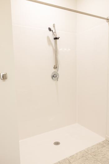 a white shower in a bathroom with a shower curtain